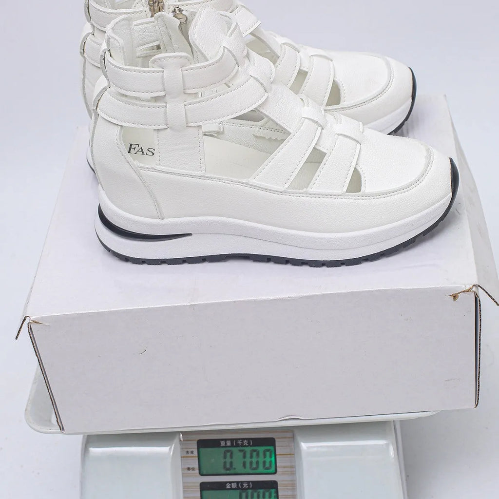 Women's black close-toed sandals with hollow-out patterning and platform sole, showing Velcro fastening