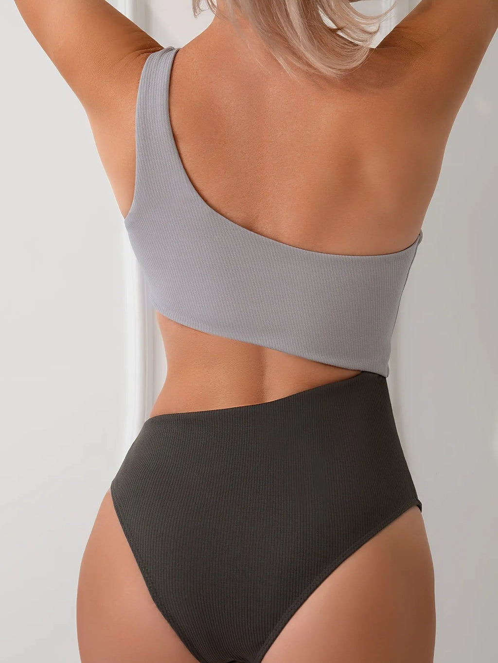 Women's light grey one-shoulder one-piece swimsuit on a mannequin.