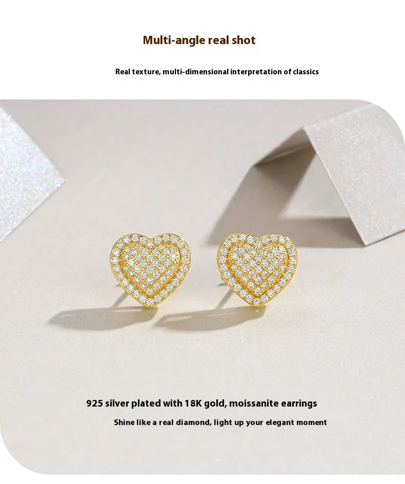 A pair of gold-toned heart-shaped stud earrings with a moissanite stone, made from S925 silver.