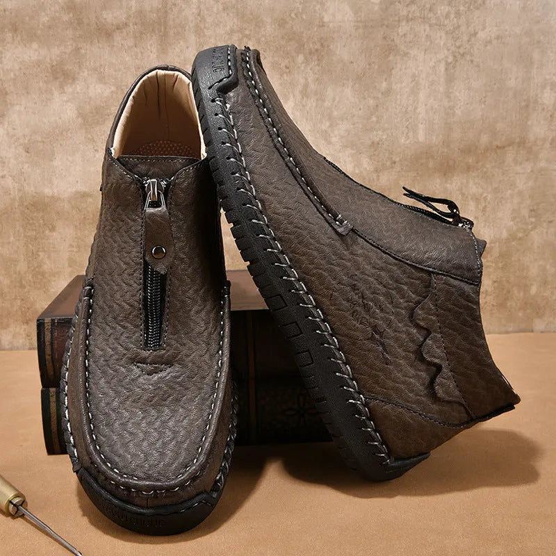 Men's black slip-on leather loafers with a round toe and rubber sole on a plain background.