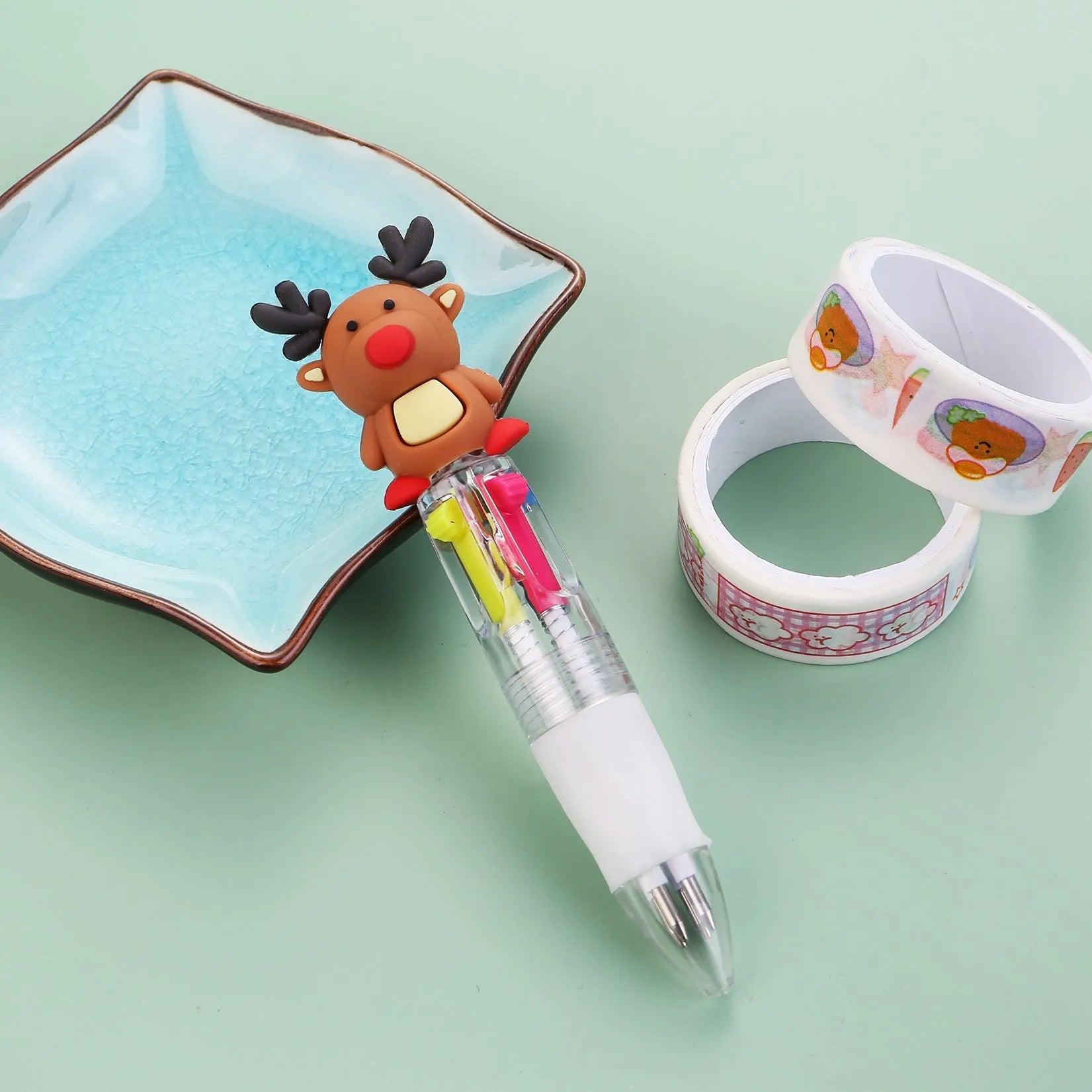 11cm long Christmas-themed four-colour ballpoint pen showing festive designs like reindeer and trees.
