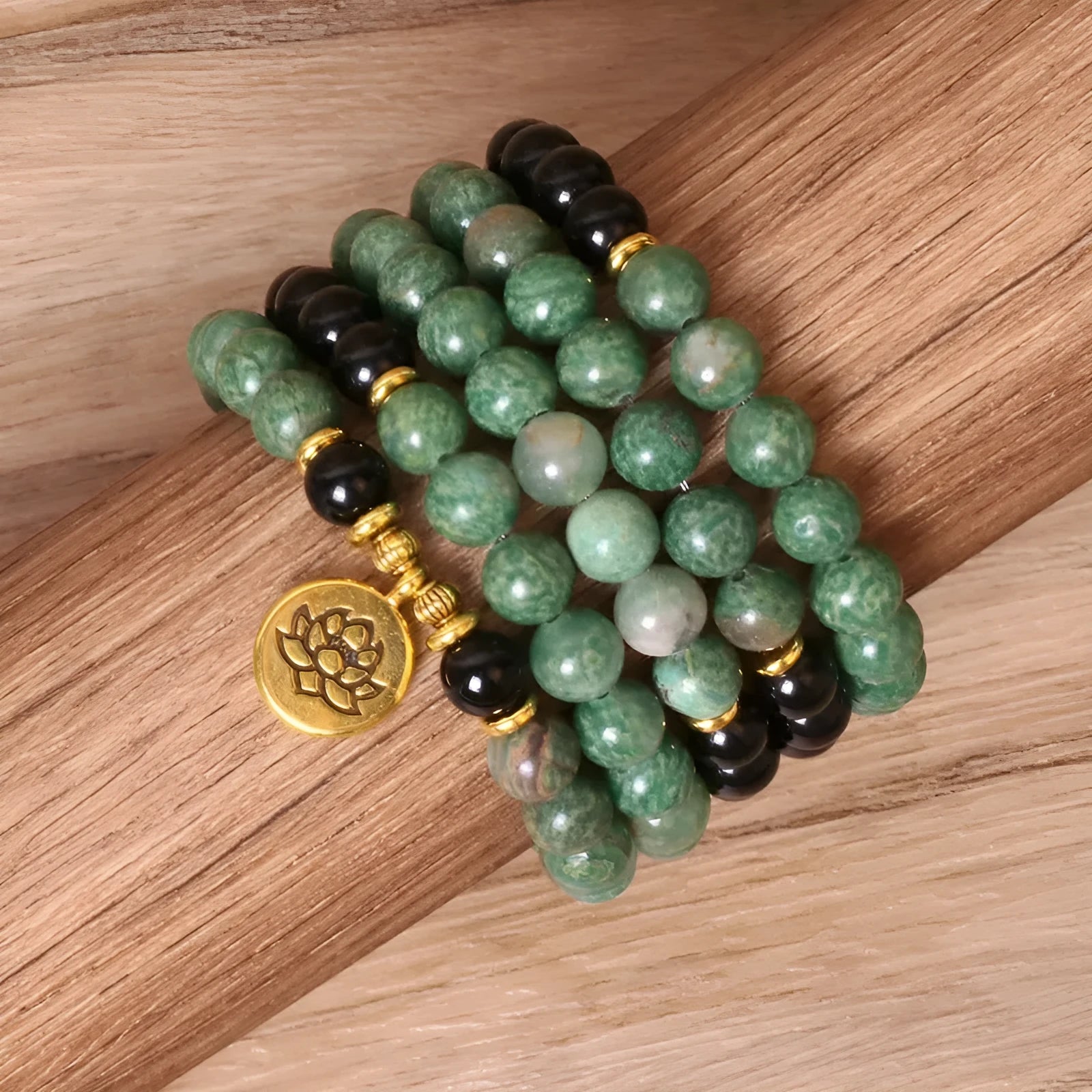 Green and black elastic beaded alloy bracelet on a wrist.