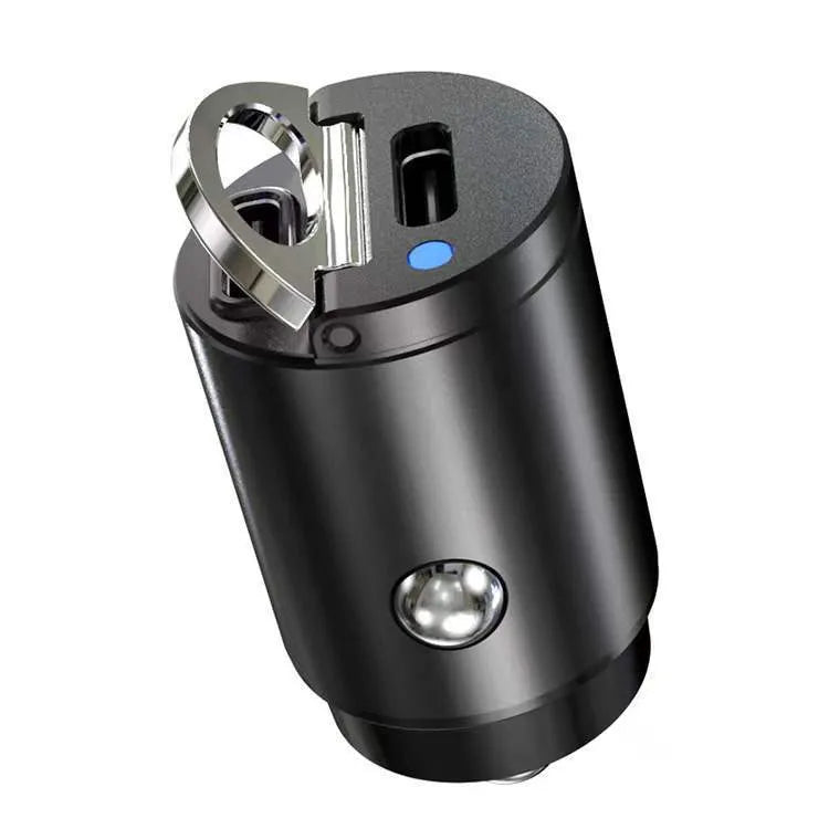 Black mini 30W dual USB car charger with zinc alloy housing next to a car cigarette lighter socket.
