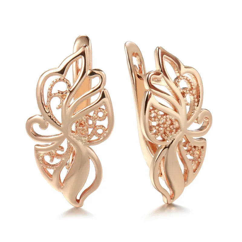 Pair of rose gold hollow carved geometric earrings with rhinestone accents on copper base