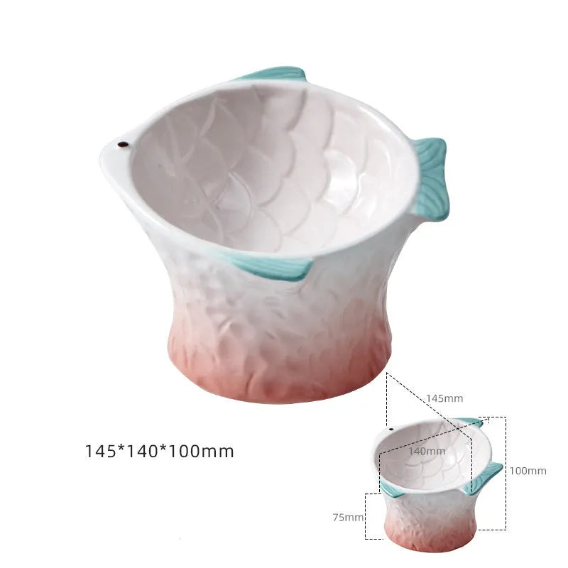 Set of four blue fish-shaped ceramic cat bowls with a tilted angle on a flat surface.