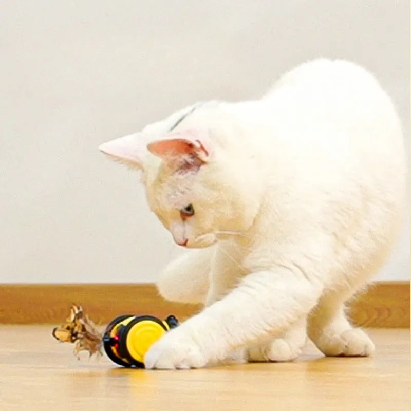 Pink and yellow bee-themed electric cat toy with feather attachment on floor