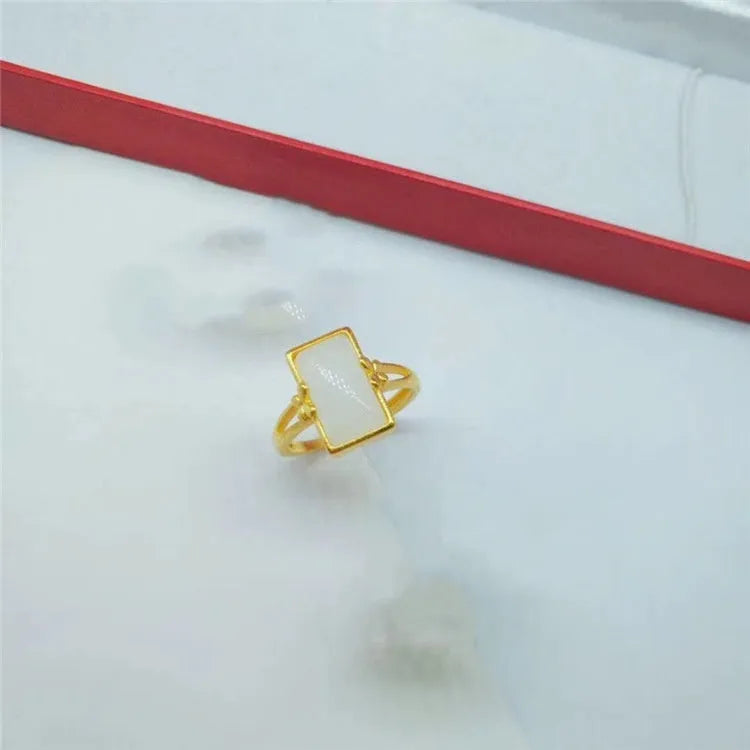 Adjustable gold-plated brass ring with a black gemstone inlay on a model's hand.