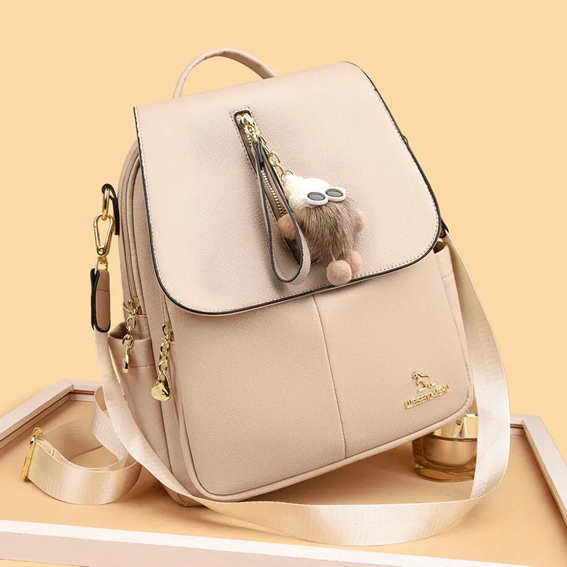 Genuine leather women's student travel backpack with pendant in beige colour, featuring covered outer pocket and belt decoration