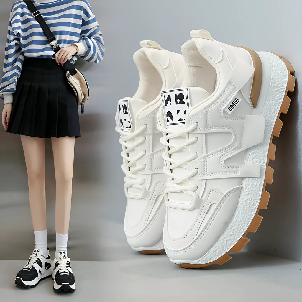 Black and white low-top lace-up sneakers with round toe and rubber sole