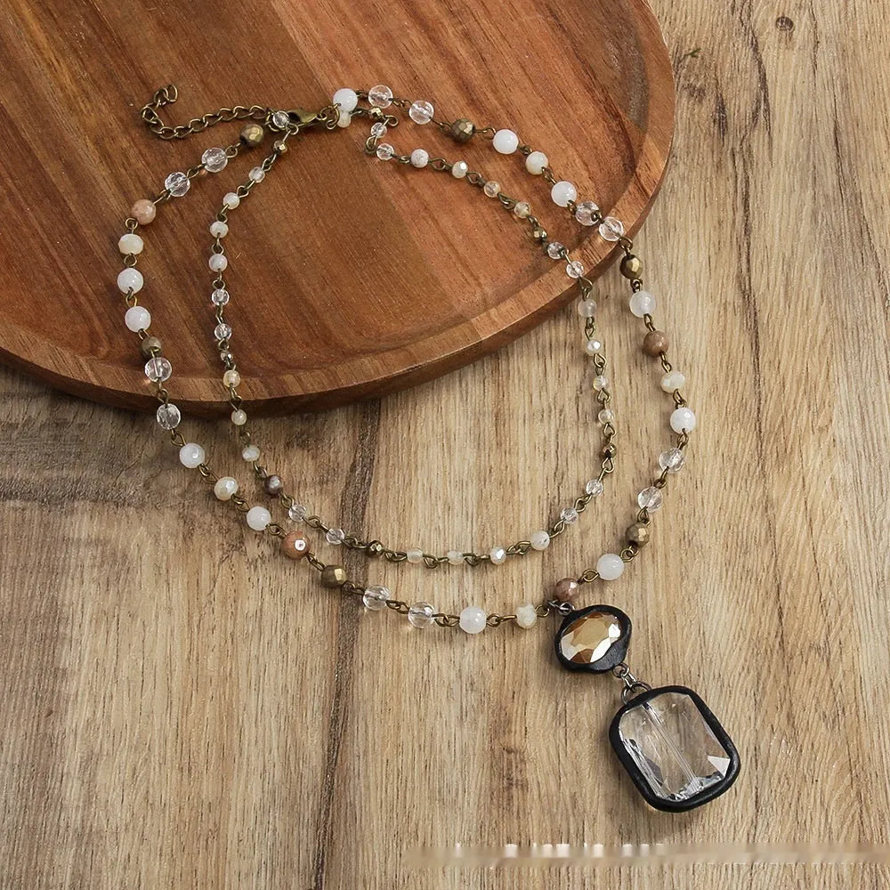 Tribal-style retro necklace with a blue stone and glass pendant on a metal chain.