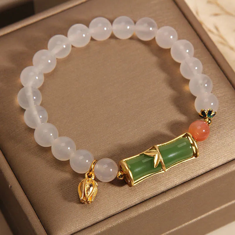 Women's white agate jade bracelet with bamboo joint design and a single bead centrepiece.