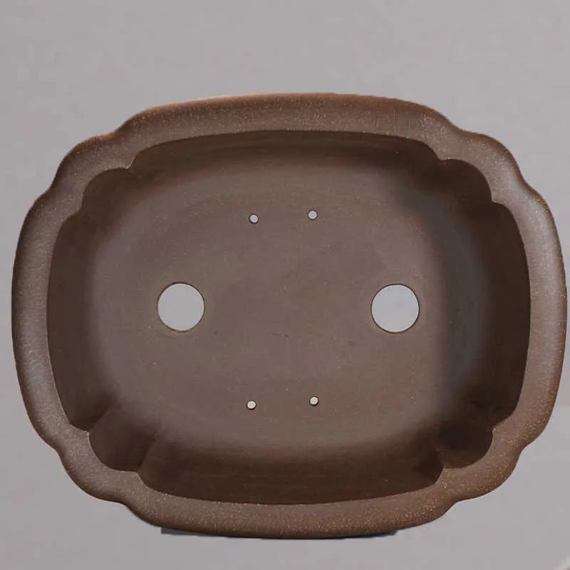 Purple clay handmade rectangular flower pot with antique design on wooden desktop