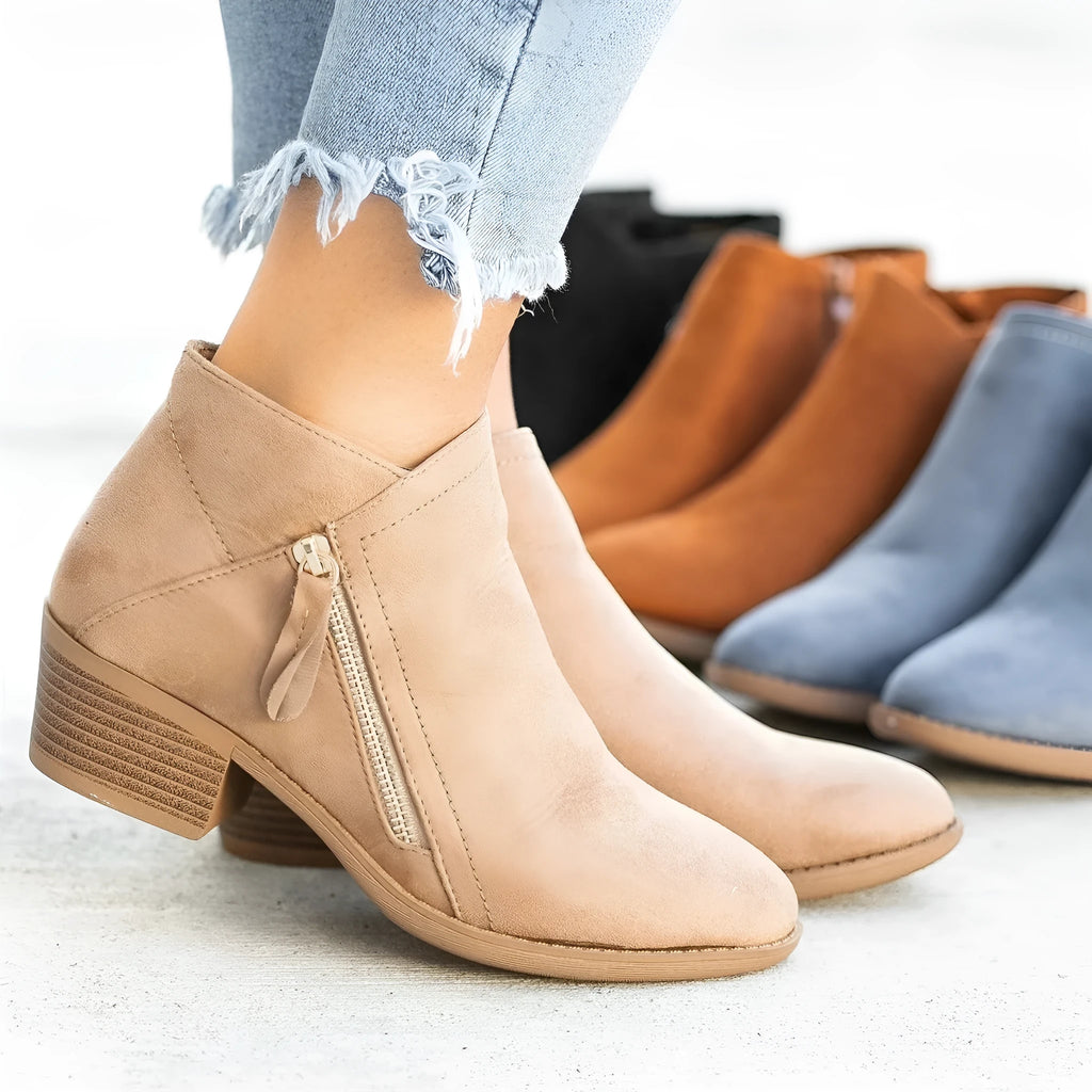 Women's beige suede ankle boots with a side zip and chunky heel on a white background.