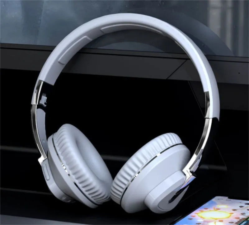 Wireless over-ear headset in black with soft ear cushions, showing AUX audio jack port.