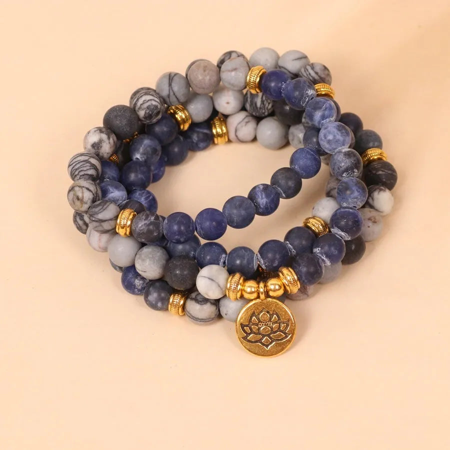 Close-up of a blue multi-layer bracelet with patterned network stone beads and a silver alloy chain.