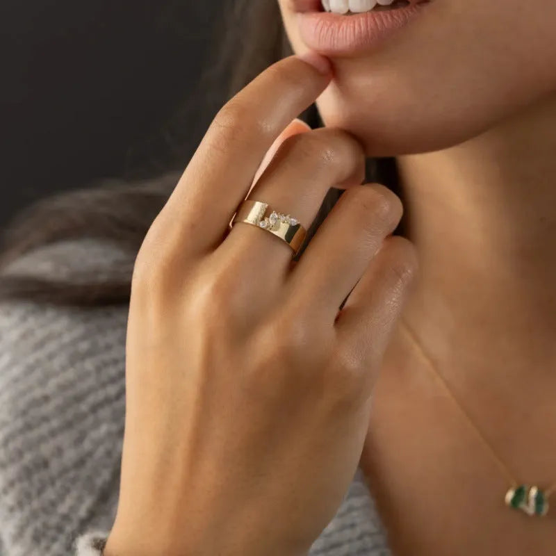Gold plated copper ring for women with shining zircon detail on a finger.