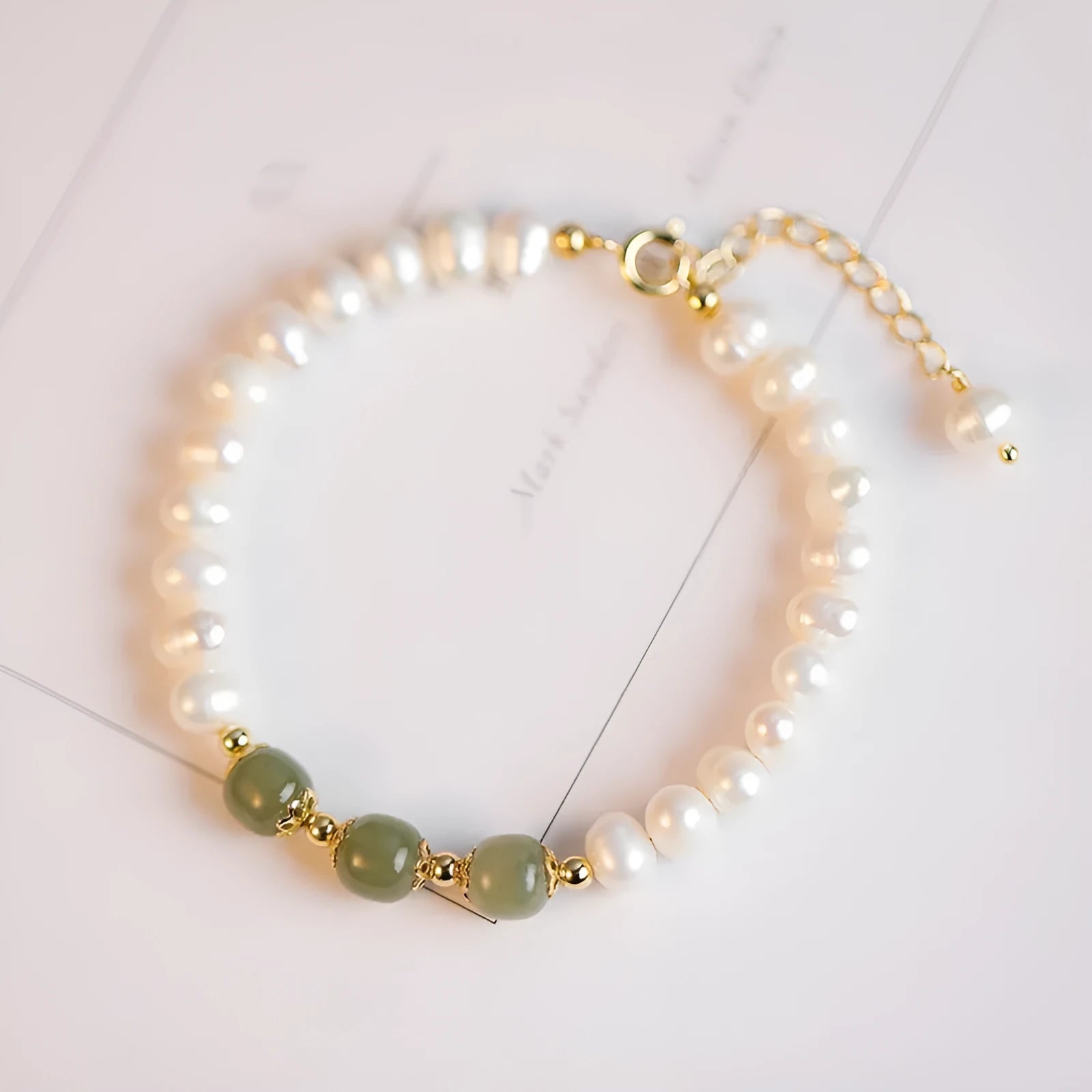 Korean style bracelet with diamond-shaped freshwater pearls in Hetian jade colour on a wrist.