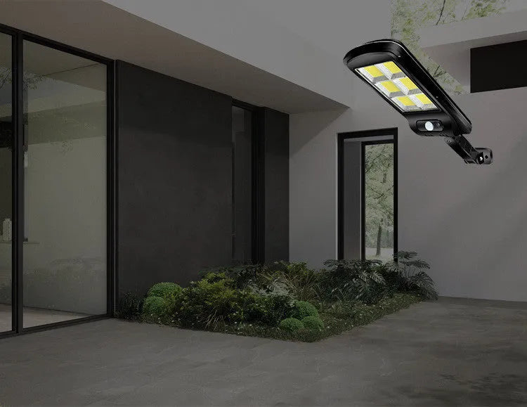 Black solar powered outdoor motion sensor light with solar panel for garden fence or driveway illumination