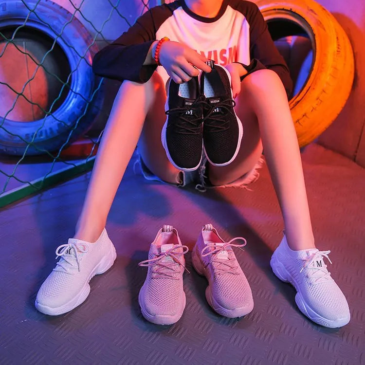 Women's white woven sports shoes with thick rubber sole and front strap.