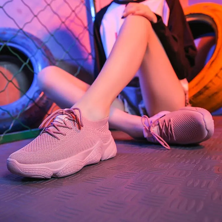 Women's white woven sports shoes with thick rubber sole and front strap.