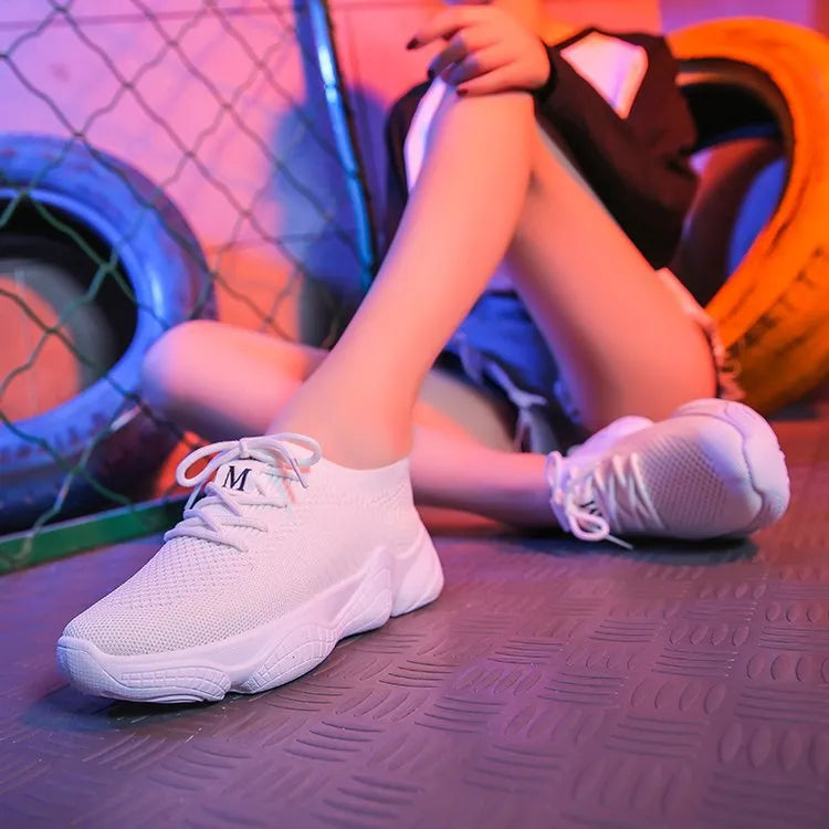 Women's white woven sports shoes with thick rubber sole and front strap.