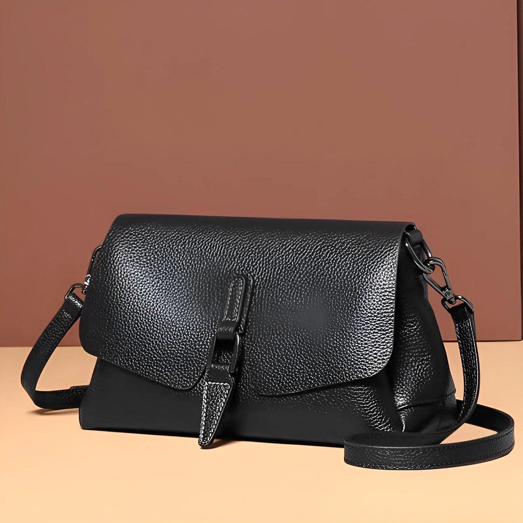 Women's soft cowhide shoulder bag in Wine Red with three main pockets and adjustable strap on white background
