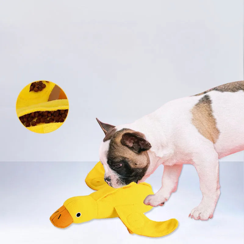 Yellow plush duck dog toy with squeaker and treat-dispensing feature for training and play.