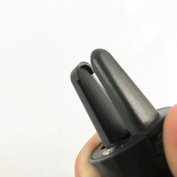 Black car phone holder attached to vehicle air vent with phone securely mounted