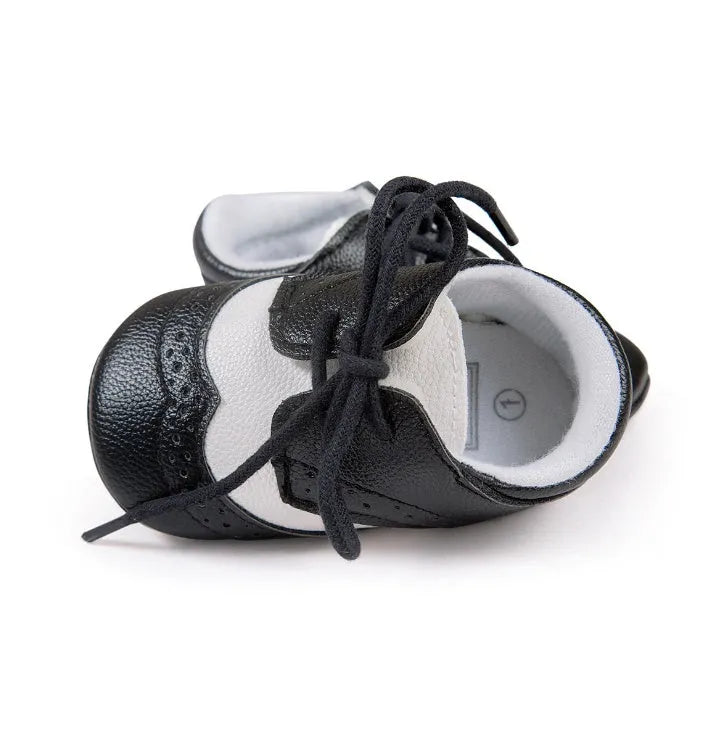 Vintage style soft-soled baby walking shoes for boys in black, grey, light brown, and white.