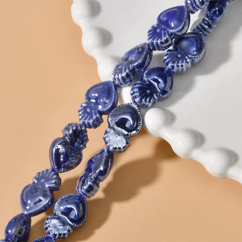 Assorted small ceramic torch beads in multiple colours on a white background.