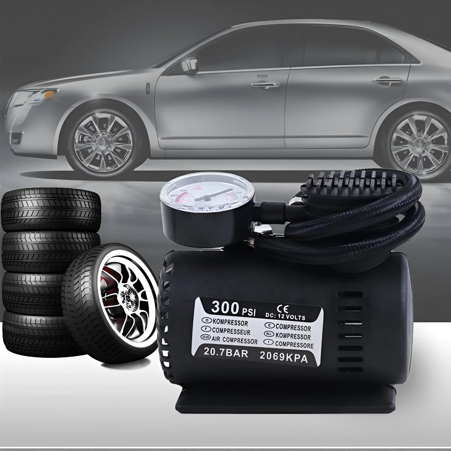 Black 12V portable mini air compressor with 300 psi gauge, 9-foot cord, and two adapter nozzles on a neutral background