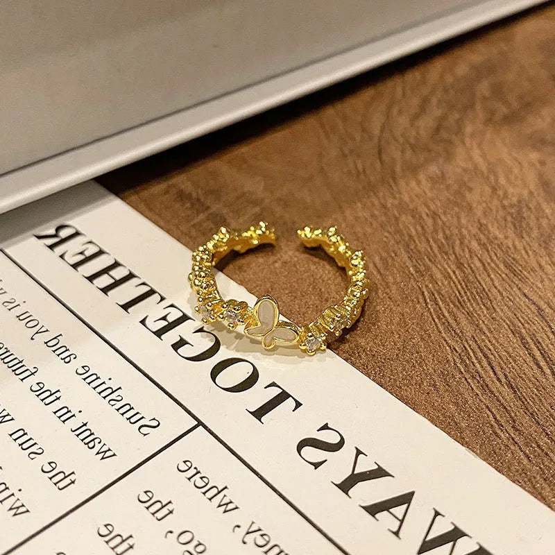 Creative copper butterfly ring with dripping oil finish, showing open loop design.
