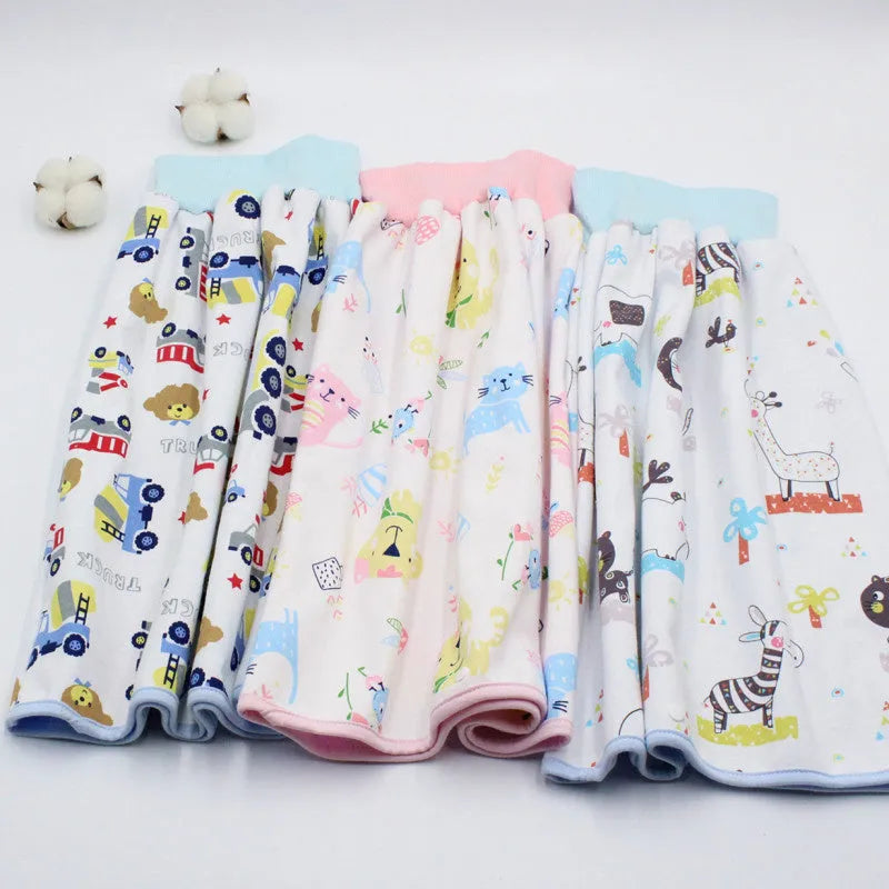 Baby girl wearing a multi-colour waterproof cotton diaper skirt with elastic waistband for belly protection
