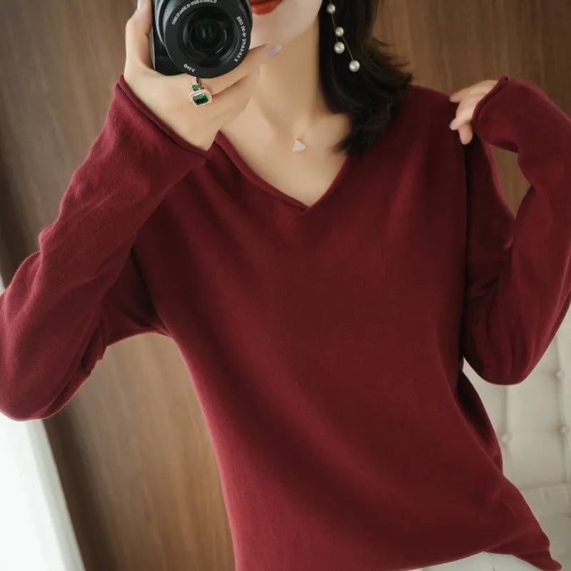 Women's V-neck long sleeve knit top in turmeric colour on a hanger