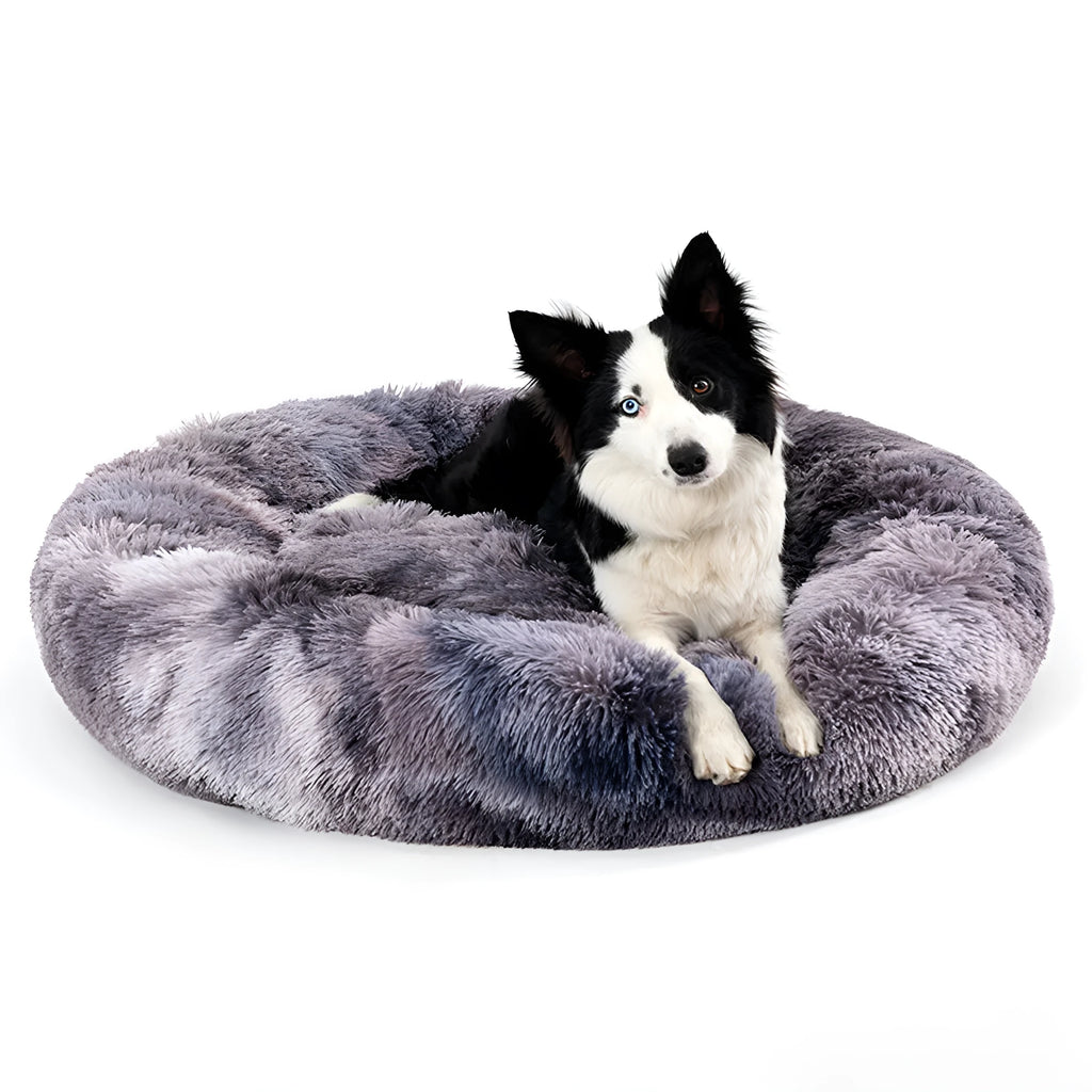 Fluffy donut-shaped pet bed in long plush material, showing raised edge and central well.