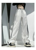 Navy blue and white loose straight leg trousers with ribbon parallel bars detail.