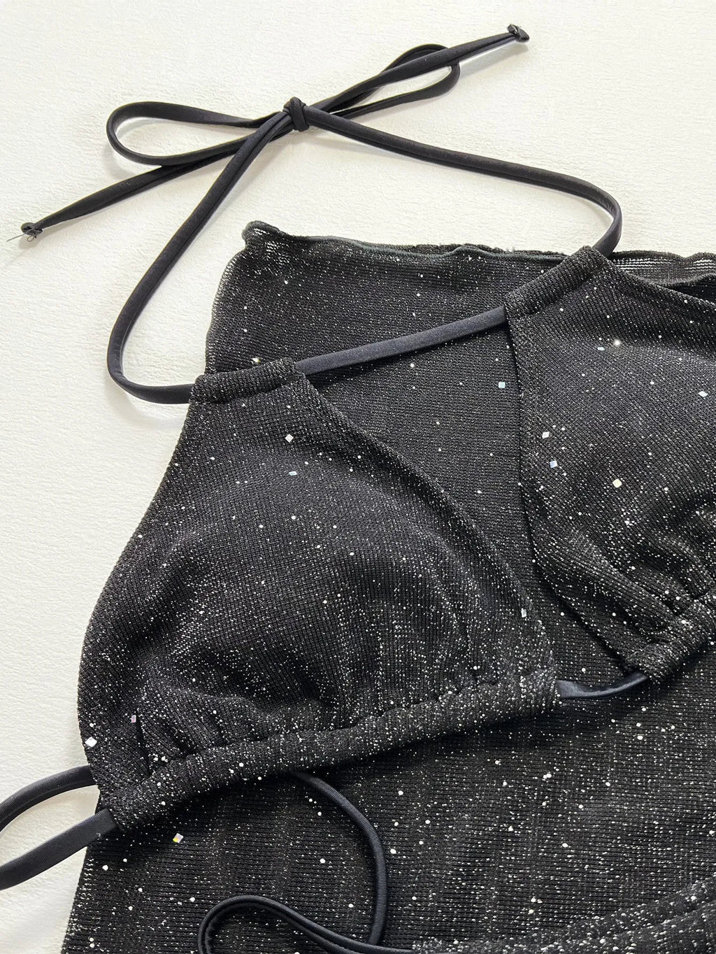 Black three-piece polyester bikini swimsuit set with top and shorts on mannequin