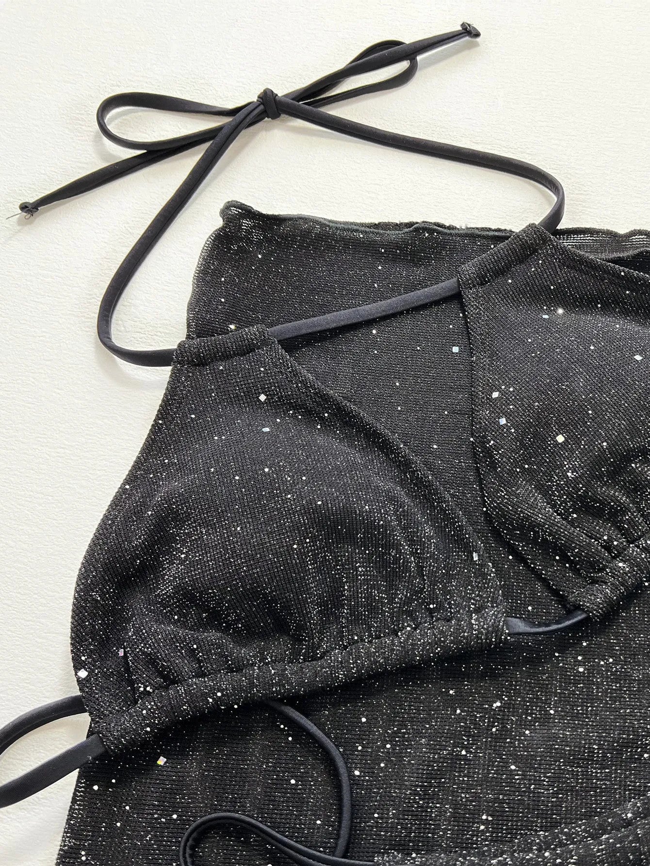 Black three-piece polyester bikini swimsuit set with top and shorts on mannequin