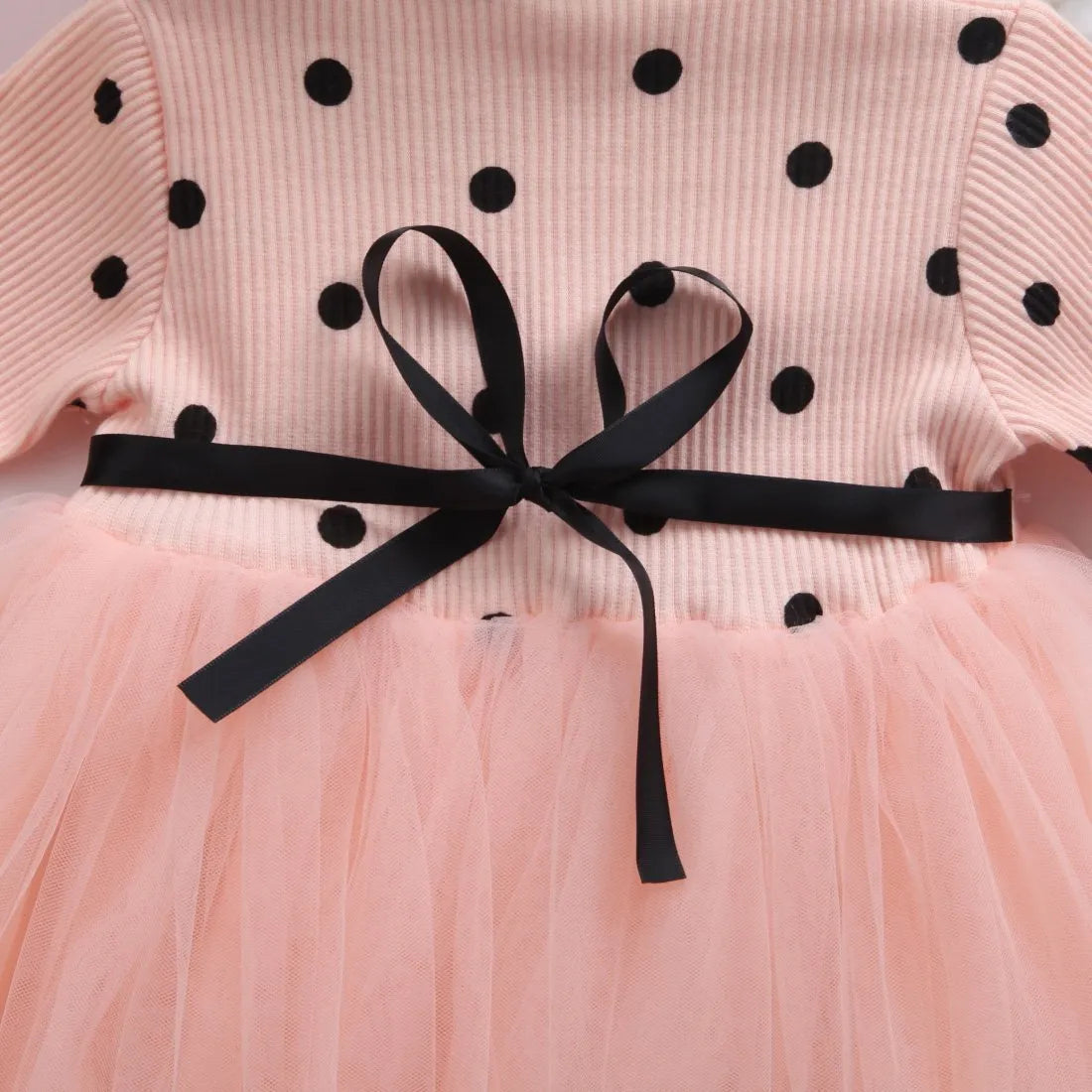A baby girl's long sleeve black tutu dress with lace detail, suitable for birthdays and christenings.