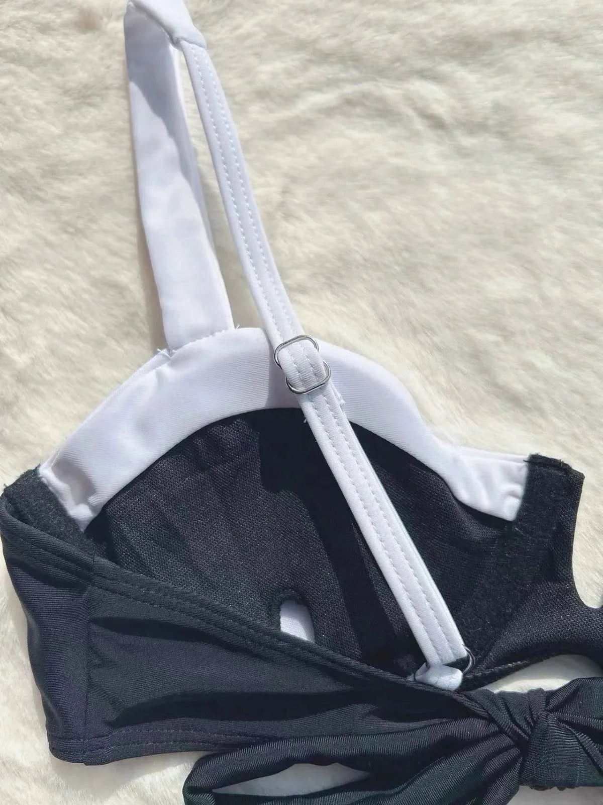 Women's black low waist bikini swimsuit with stitching split detail on mannequin
