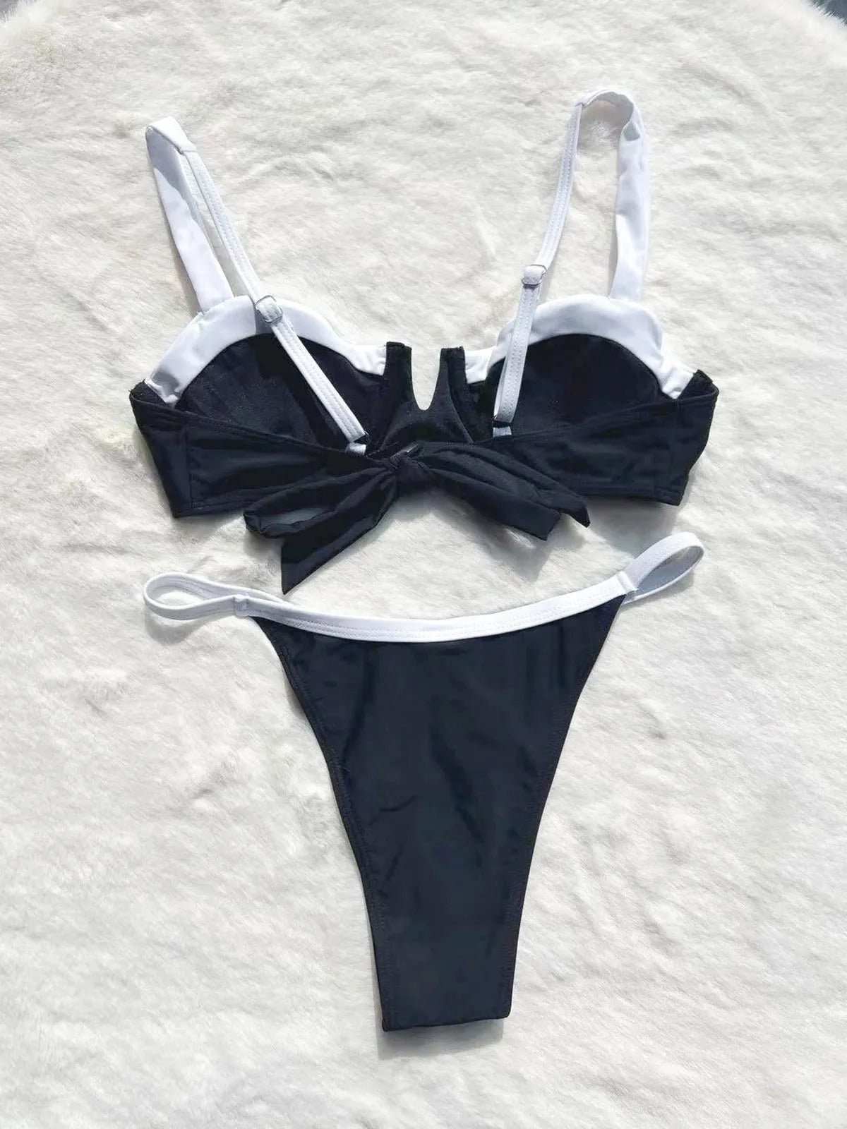 Women's black low waist bikini swimsuit with stitching split detail on mannequin