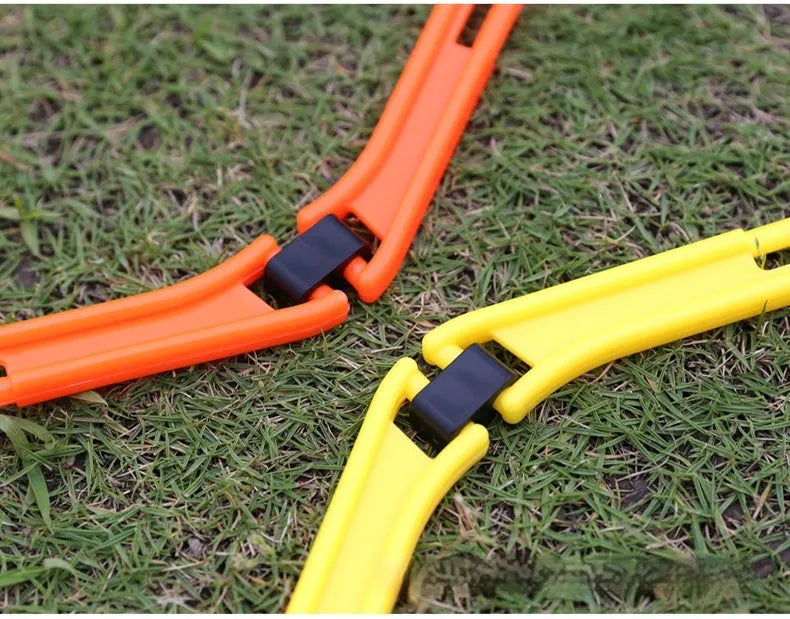 Set of six foldable yellow, green, and orange hexagon football agility training rings on grass