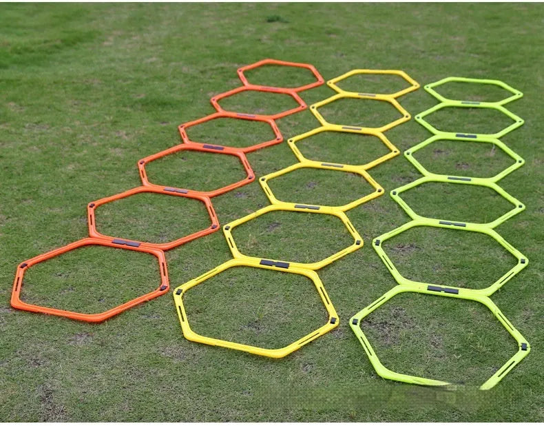 Set of six foldable yellow, green, and orange hexagon football agility training rings on grass