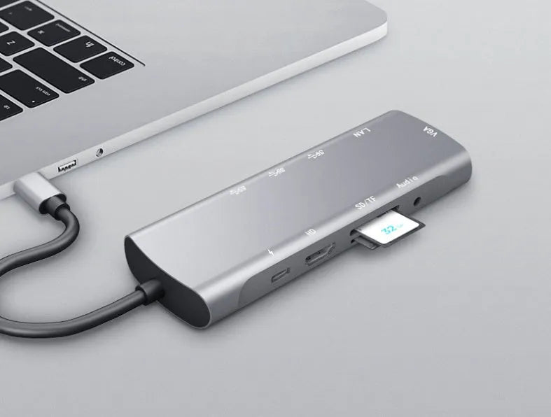 Grey aluminium USB-C docking station showing HDMI, VGA, USB 3.0, PD charging, and card reader ports.
