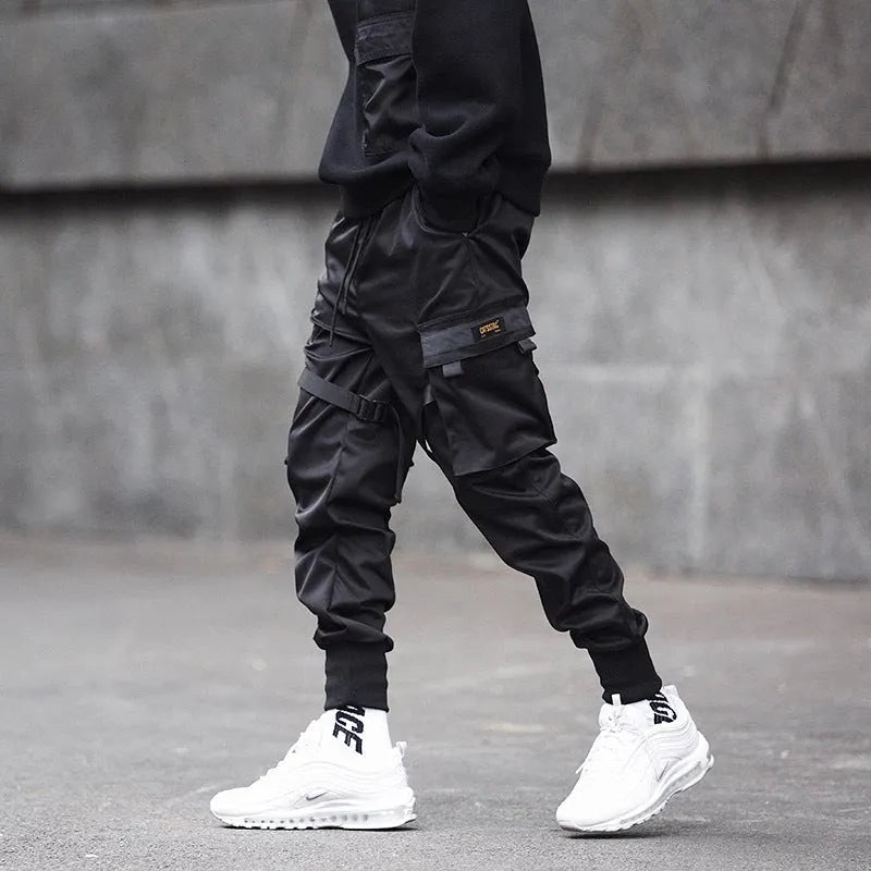 Black cotton overalls with tapered leg and small foot opening on plain background