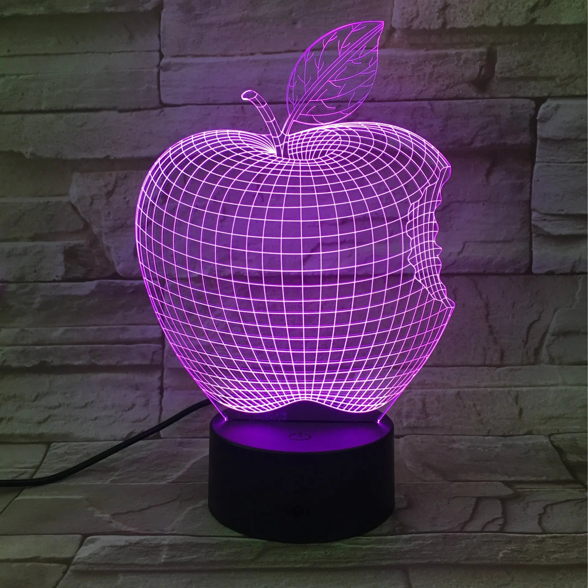 3D fruit-shaped colourful LED night light with touch control on a table.