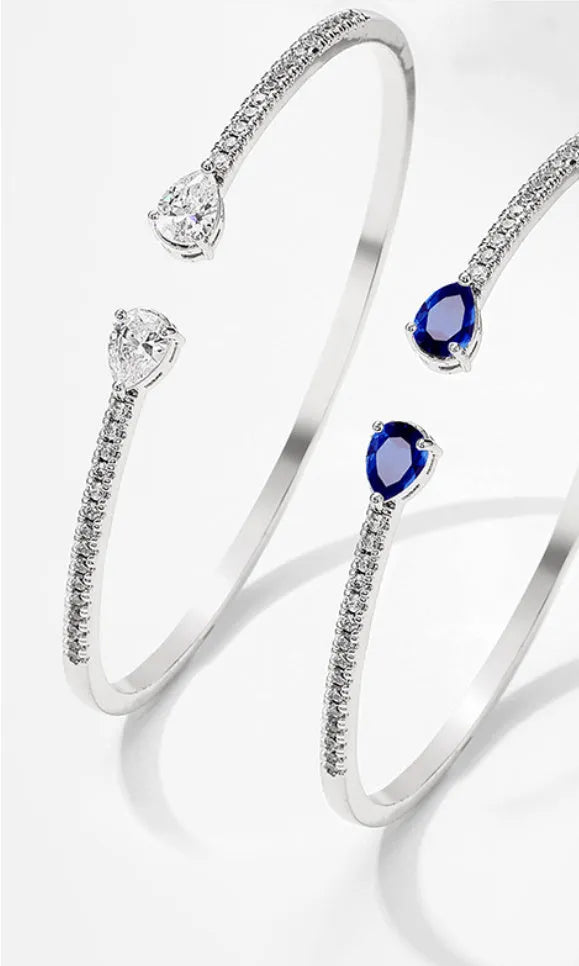 Copper bracelet with inlaid zircon stones in a simple design, shown in white and blue colour options.
