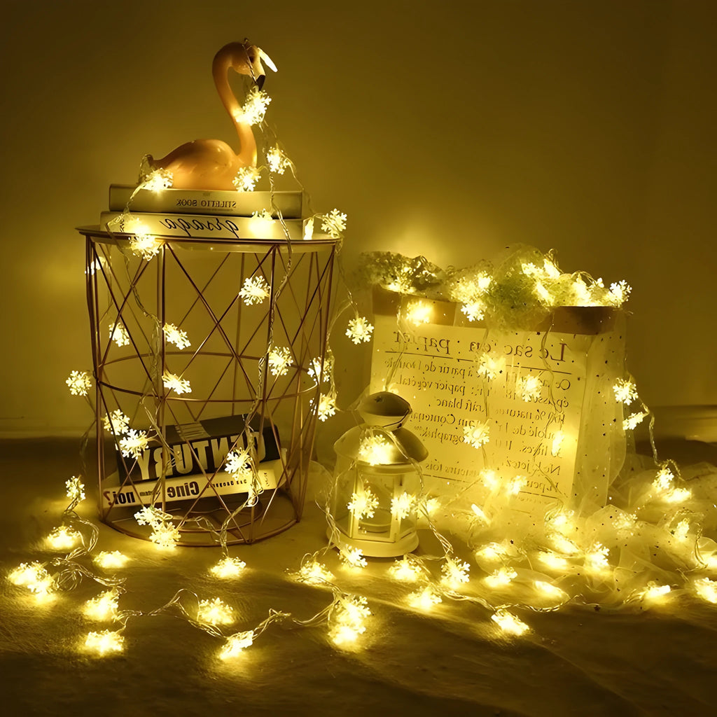 Battery powered LED snowflake string lights with star decorations lit on a dark background