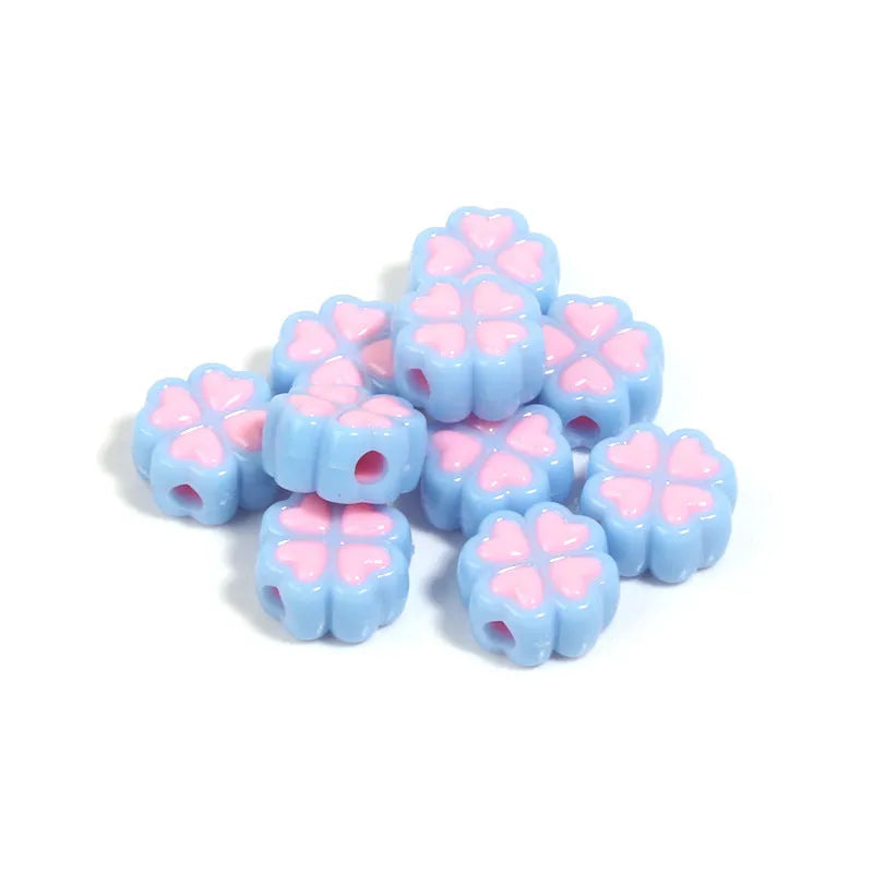 A selection of 15mm frosted acrylic beads showing a raised cartoon love and four-leaf clover pattern in various colours.