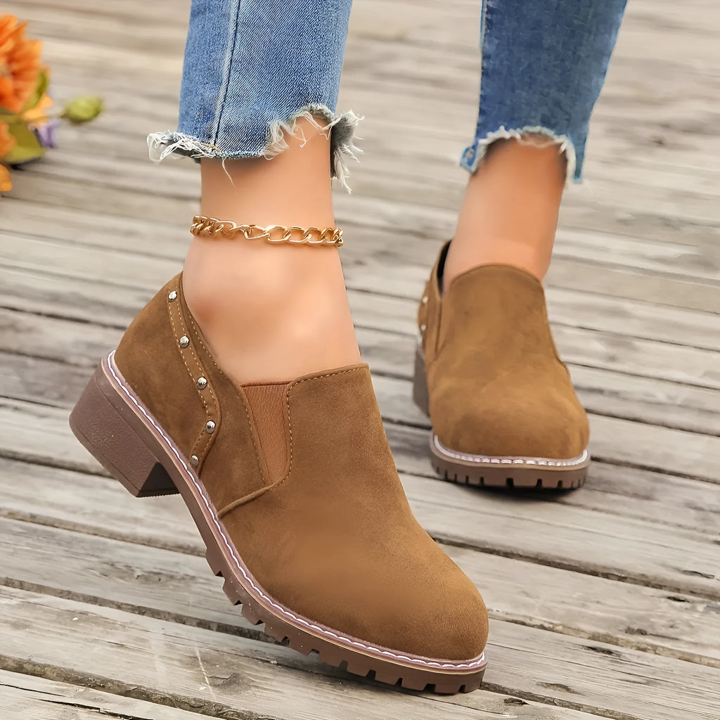 Women's light brown suede ankle boots with a low thick heel and elastic band fastening.